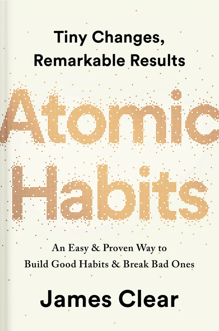 Atomic Habits book cover. Words, Atomic Habits, are big and made of yellow particles as if they are atoms.